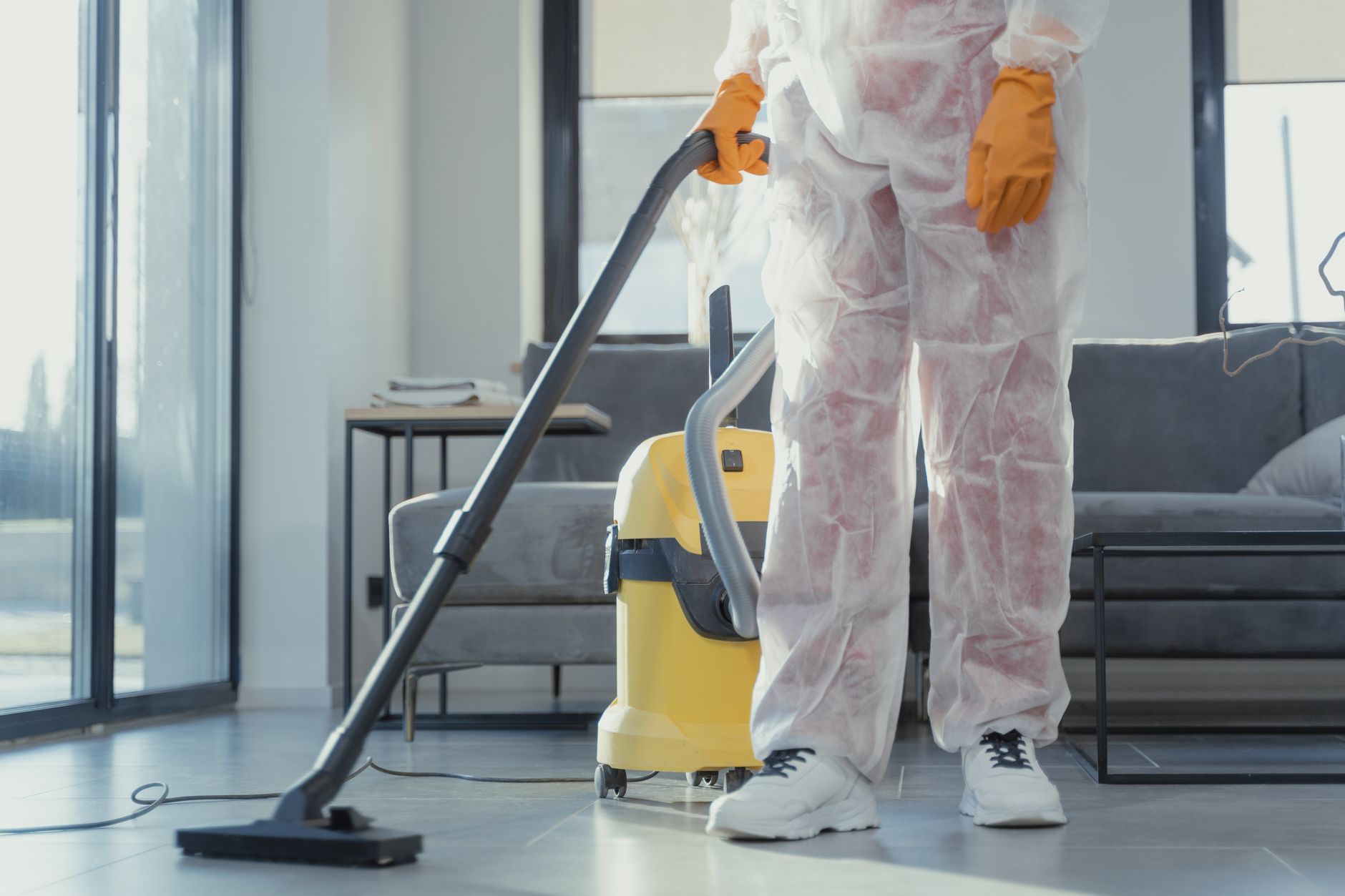 A certified mold remediation technician from Tech Pro Mold Removal inspecting a damp area in an Allen home with a moisture meter.